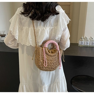 Detailed shot of handmade straw bag with pink tassel handles and drawstring lining