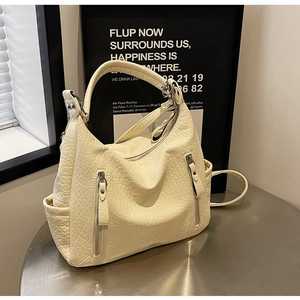 Gros plan détaillé du sac fourre-tout crème texturé avec fermetures éclair métalliques