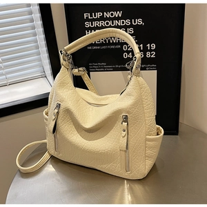Détail du sac Hobo blanc crème montrant la texture crocodile et fermetures éclair