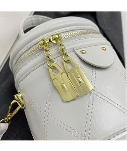 Close-up of white quilted leather bucket bag with dual gold zippers and metal hardware