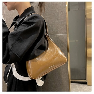 Detail of brown oil-wax leather Hobo shoulder bag featuring a sleek crescent silhouette