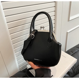 Detail of minimalist black handbag with silver metal clasp and leather strap
