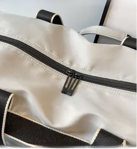 Detail of smooth black double zippers on gray water-resistant gym travel bag