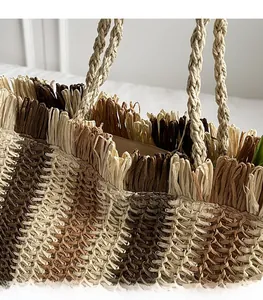 Close-up of multicolor woven straw beach bag showing fringe edges and braided handles