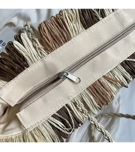 Detail of the high-quality silver metal zipper and woven texture on a beige straw tote bag