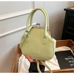 Detail of lime green faux leather handbag with vintage metal clasp and fashion logo