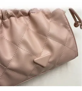 Close-up of pink quilted leather bucket bag with drawstring detail and metal triangle