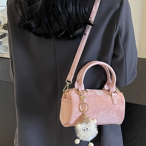 Pink suede Boston cylinder handbag with plush charm and detachable shoulder strap