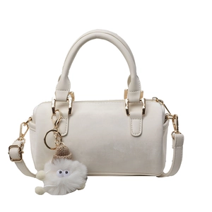 Chic cream Boston barrel handbag with plush charm and adjustable strap for women
