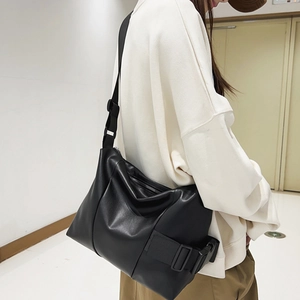 Women's black faux leather tote bag with wide adjustable strap for casual daily use