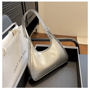 Detailed shot of silver hobo shoulder bag with metallic crinkled texture in a gift box