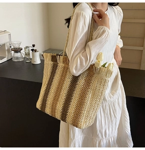 Detail of striped woven straw tote bag with tassels and tulips in a modern cafe setting