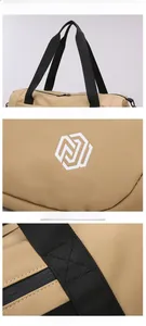 Detail view of khaki travel bag showing reinforced stitching and logo on durable fabric