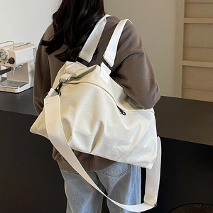 White nylon tote bag with black zipper detail and adjustable crossbody strap for women