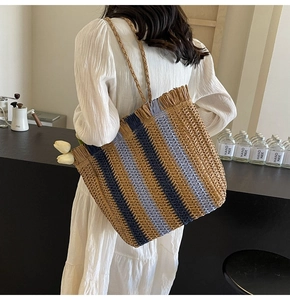 Detail of hand-woven striped straw tote bag with fringe edge and large capacity