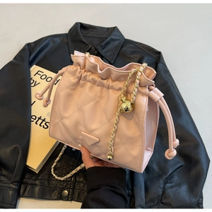 Detail of pink quilted bucket bag showing chain strap and drawstring closure