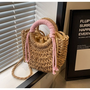 Detail of hand-woven straw bag with pink rope handle and secure drawstring liner
