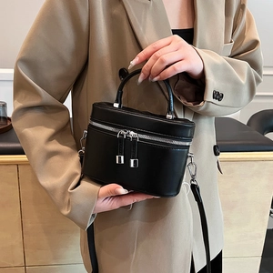 Sac cosmétique chic en cuir noir avec zips argentés présenté dans un cadre élégant