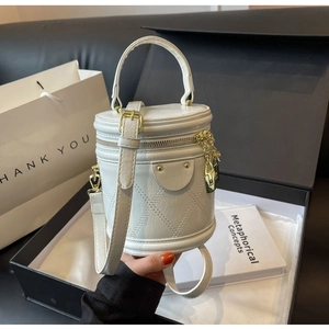 Detailed shot of a quilted white bucket bag inside a black gift box with gold hardware