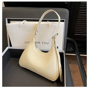 Close-up of beige moon bag with metal buckle and logo in premium gift box packaging