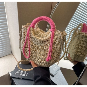 Detail of handwoven straw bag with pink cord handles and a beige drawstring inner bag