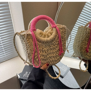 Detail of woven straw bag with magenta rope handle and drawstring lining for vacation