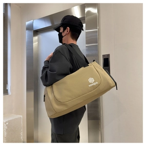 Detail of khaki canvas travel bag with NINGJIA logo and black nylon shoulder strap