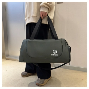 Large capacity dark green travel duffel bag showing side zipper pocket and adjustable strap