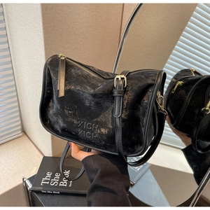 Détail du sac Boston en cuir noir texturé avec logo embossé et fermeture éclair