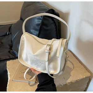 Détail du sac Boston en cuir crème texturé avec le logo embossé XICH XICH