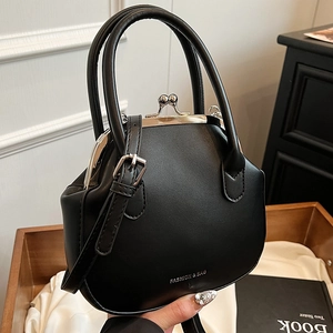 Classic black leather kiss-lock handbag with circular handles and adjustable shoulder strap