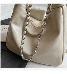 Detail of cream hobo bag with silver chain strap and supple leather texture