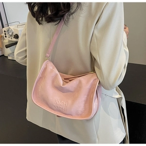 Sac Boston en daim rose avec lettrage XICH XICH embossé porté par un mannequin chic