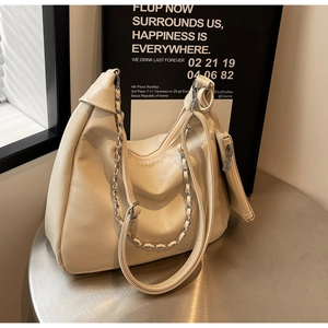 Detail view of the beige PU leather tote with a silver chain and small coin purse