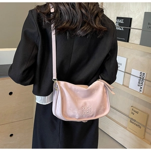 Détail du sac Boston rose clair avec lettrage embossé et ferrures métalliques dorées