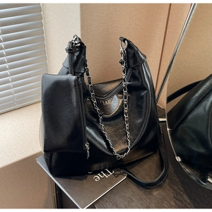 Close-up of black tote bag with vintage wrinkled texture leather and silver chain