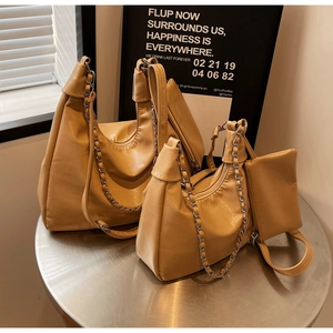 Detail of yellow tote bag set showing wrinkled leather texture and silver chain strap