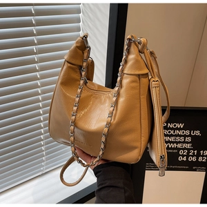 Detail of ginger yellow leather half-moon tote with silver chain and matching pouch