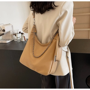 Detail of camel leather tote with silver chain and matching pouch worn on shoulder