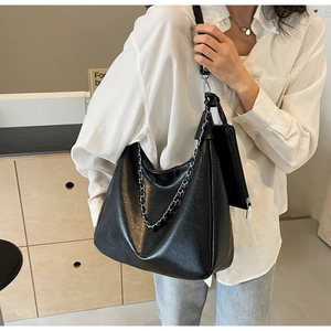 Detail of black pebbled leather tote with silver chain and matching zipper pouch
