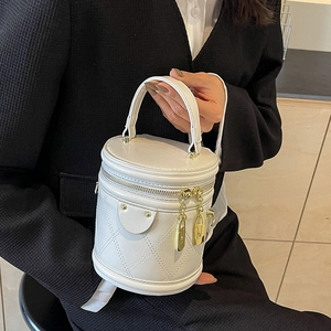 Chic white bucket bag with diamond stitching and golden hardware in a vertical design