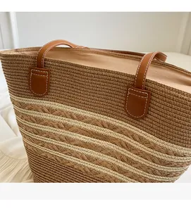 Détails du tissage en paille et poignée en cuir marron avec surpiqûres blanches