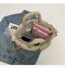 Macro view of spacious quilted tote bag interior holding tablets and daily essentials