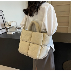 Quilted tote bag showing beige padded lattice texture and double shoulder strap design