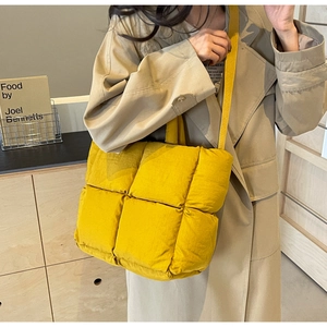 Model wearing yellow quilted puffer tote bag with wide strap for versatile daily styling
