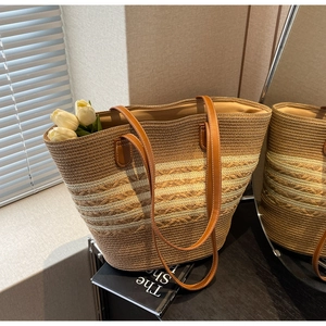 Vue détaillée du sac cabas en paille tressée avec anses en cuir brun et rayures chic