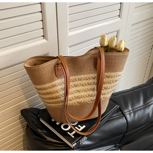 Détail du sac cabas en paille tissé avec anses en similicuir marron et surpiqûres