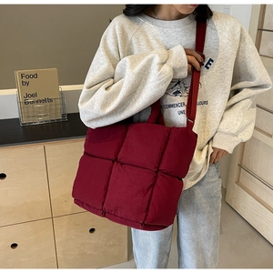 Close-up of wine red quilted tote bag with soft padded texture and adjustable strap