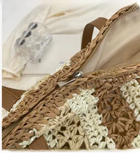 Détail de la fermeture éclair en métal et texture tissée sur un grand sac en paille