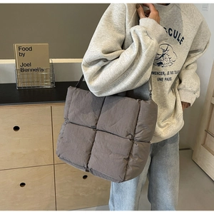 Taupe padded quilted tote bag with thick strap shown in a modern lifestyle setting